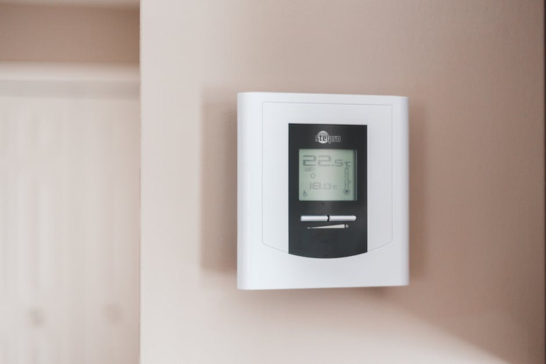 Modern digital thermostat on wall showing temperature - energy saving and home heating efficiency