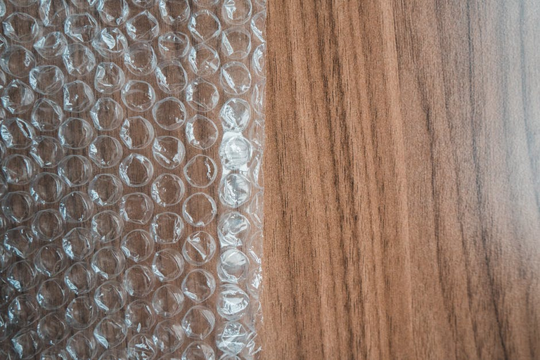 Bubble wrap sheet on wooden surface showing packaging material types suitable for window insulation