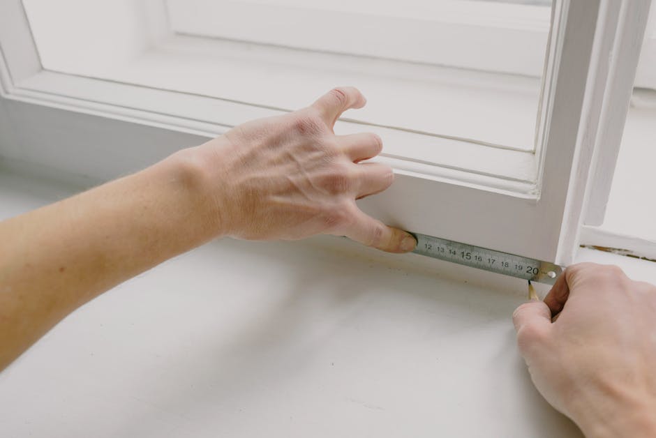Worker measuring window frame for DIY secondary glazing installation