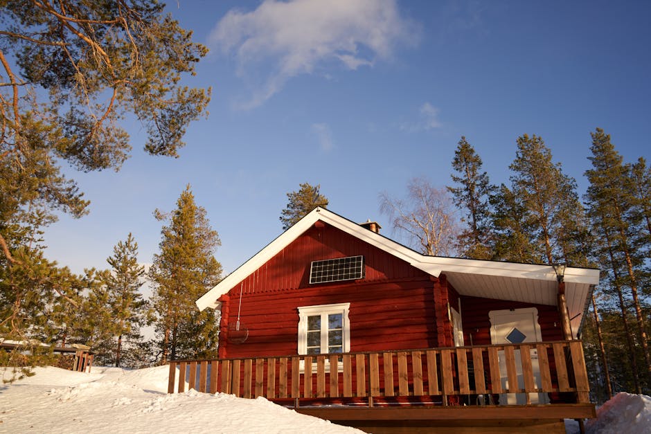 Rustic red cabin with solar panel in winter snow — a DIY solar air heater is the most practical way to add free supplemental heating to a cabin or workshop
