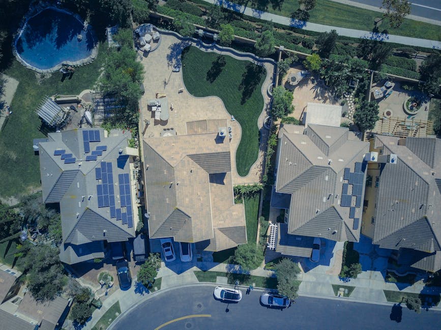 Aerial view of eco-friendly suburban homes with solar panels — UK solar grants and incentives in 2026 including 0 percent VAT and Smart Export Guarantee payments